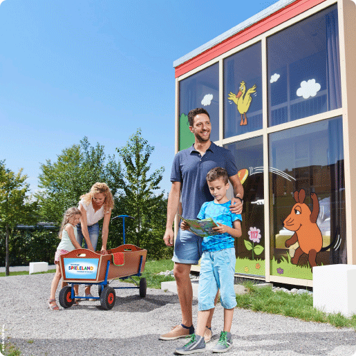 Ferienhaus_Bild_ Familie im Feriendorf vor Ferienhaus